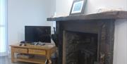 Other aspect of sitting room with TV and log burner