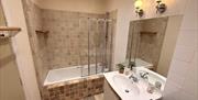 Douglas boutique holiday apartment with spacious family bathroom featuring a bathtub and shower screen