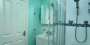 The bathroom at the cottage with bath, shower, toilet and wash basin