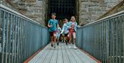 Children running across the drawbridge at Castle Rushen
