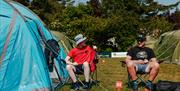 Two TT fans sitting outside tents at Peel TT Village