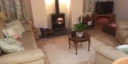 Spacious and comfortable with a lovely wood burning stove The Byre sitting room has WiFi, TV and DVD player plus an assortment of games.