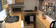 Galley style kitchen with oven, microwave, washer/dryer, fridge and all relevant kitchen accessories