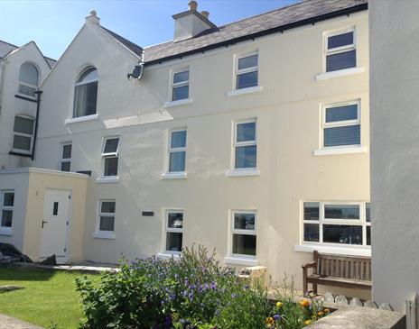 Photo of Laxey Beach Apartment situated on the second floor of cream rendered property