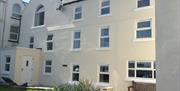 Photo of Laxey Beach Apartment situated on the second floor of cream rendered property