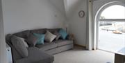 5 seater corner sofa with built in double sofa bed and view through 2 metre window to Laxey Beach