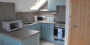 Fully fitted kitchen in open plan apartment with velux window above