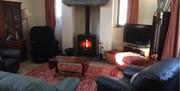 The Stables sitting room has a lovely wood burning stove surrounded by comfortable settees, TV and DVD player with WiFi throughout