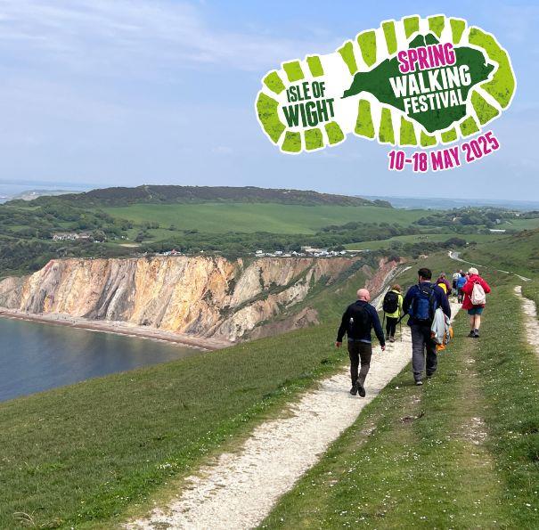 Group of walkers walking along the clifftop towards the Needles during the Isle of Wight Walking Festival