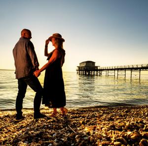 Couple watching a sunset on Totland beach, Isle of Wight