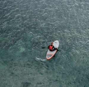 Person sitting on a paddleboard in the open water on the Isle of Wight