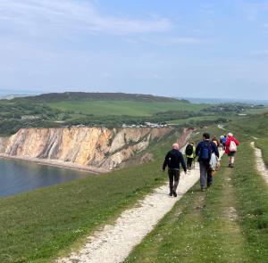 Group of walkers walking along the cliff with sea views on the Isle of Wight