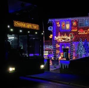 Southern Vectis bus in front of a house decorated with lights on the Isle of Wight