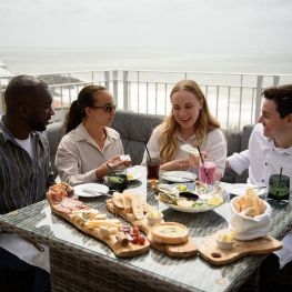 Group of people enjoying food on the balcony at The Wellington Hotel on the Isle of Wight