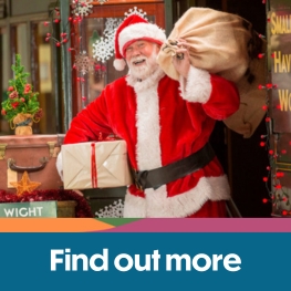 Father Christmas standing on the platform next to a train at Isle of Wight Steam Railway