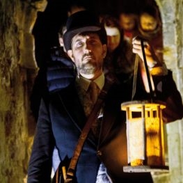 Man with lantern exploring Carisbrooke Castle on the Isle of Wight