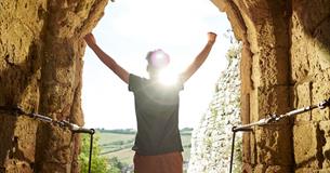 Man standing in arch of Carisbrooke Castle looking at the view, historic attraction, family fun, children's activities, summer event, what's on, Isle