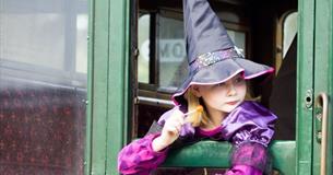 Girl dressed up as a witch looking out of the carriage window at the Wizard Week event, Isle of Wight Steam Railway, what's on