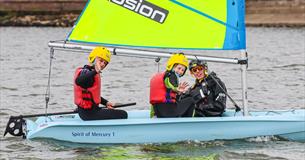 Two children and instructor in a dinghy on the water, UKSA event, what's on, children's activity, watersports, Easter event, Cowes, Isle of Wight
