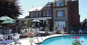 Outside swimming pool with dining chairs at Eastmount Hall Hotel, Shanklin, Isle of Wight