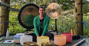 Mel sitting with bowls and gongs to provide a sound bath in the forest on the Isle of Wight, wellness, retreat, activity, health and wellbeing, sanctu