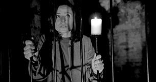 Girl standing behind bars with candle, The Lost Crypt Escape Room at Aspire Ryde, Isle of Wight, Things to Do