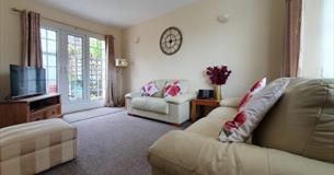 Lounge with french doors opening onto the patio in the garden at West View Holiday Cottage, Ryde, Self-catering