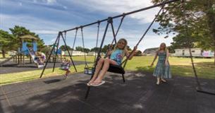 Child on the swing at the playground at Sandhills Holiday Park, Bembridge, Isle of Wight