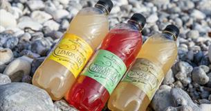 Selection of soft drinks produced by Wight Crystal laid on the beach, Isle of Wight, local produce, let's buy local