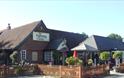 Outside view of The Fighting Cocks with outside seating area, Arreton, pub