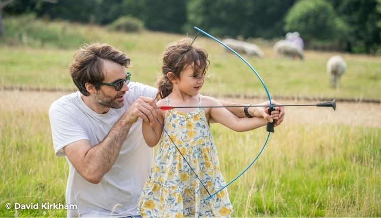 Father helping daughter with archery, National Trust event, Newtown National Nature Reserve, events, what's on, Isle of Wight - photo credit: David Ki