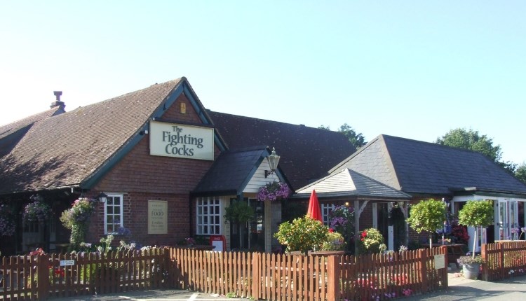 Outside view of The Fighting Cocks with outside seating area, Arreton, pub