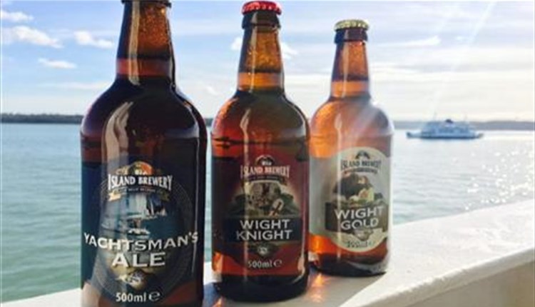 Three bottles of beer on ledge overlooking solent with ferry in background, Isle of Wight, Local Produce, Island Brewery, let's buy local