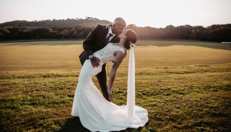 Couple kissing outside within the grounds of Newclose County Cricket Ground with the sun setting, weddings on the Isle of Wight, celebration, family,