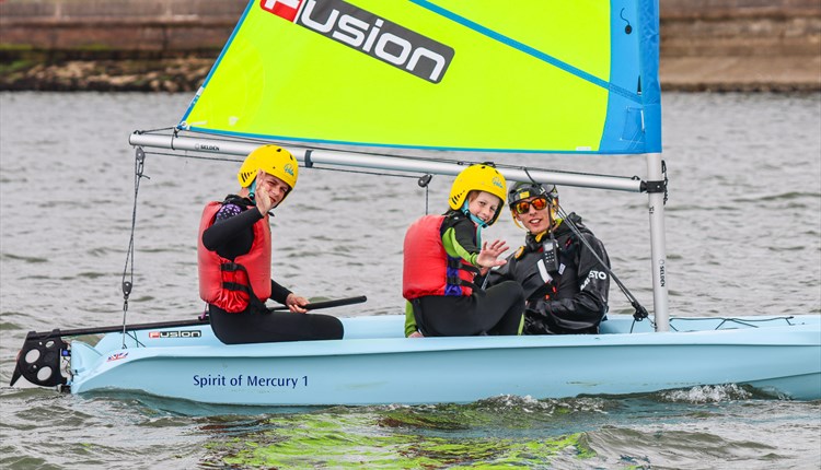 Two children and instructor in a dinghy on the water, UKSA event, what's on, children's activity, watersports, Easter event, Cowes, Isle of Wight