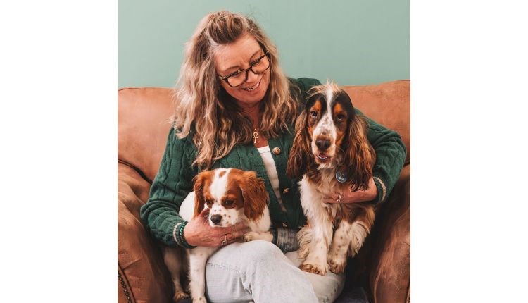 Suzanne Wright with two dogs on her lap sitting on the sofa, Wright Zone Doggy Care, dog friendly, dog day care, Isle of Wight