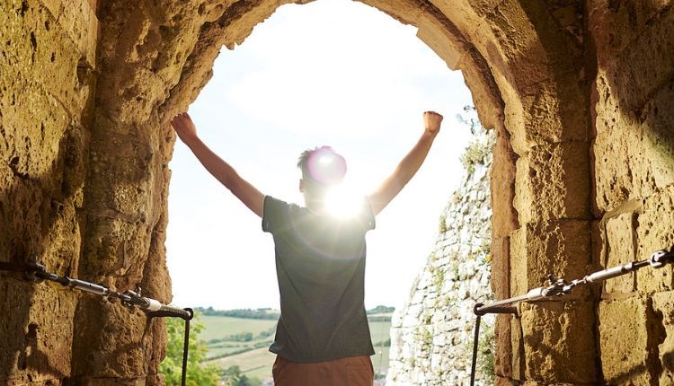 Child putting arms in the air looking out to the view at the top of Carisbrooke Castle, Easter event, family fun, Isle of Wight, what's on