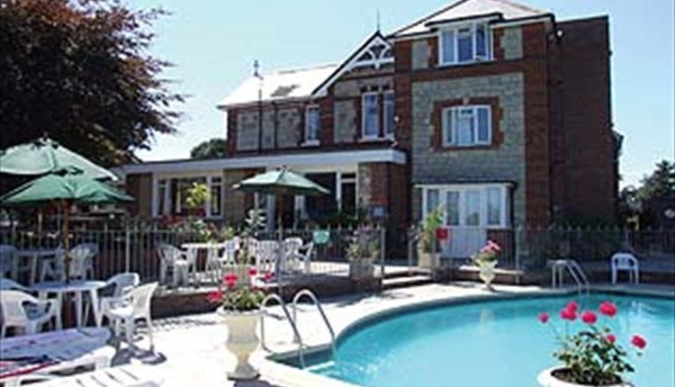 Outside swimming pool with dining chairs at Eastmount Hall Hotel, Shanklin, Isle of Wight