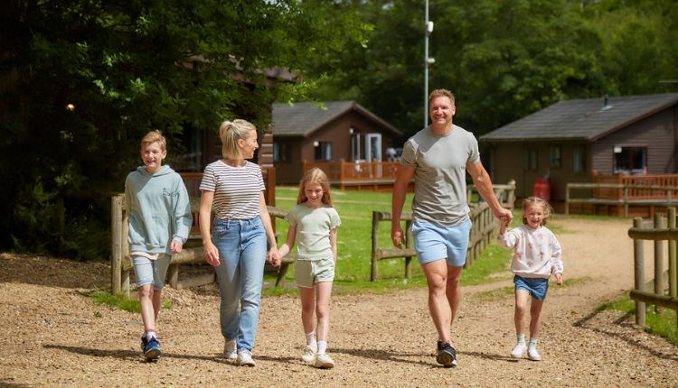 Family walking around the park with the lodges in the background at Landguard Holiday Park, caravans, lodges, Shanklin, Isle of Wight