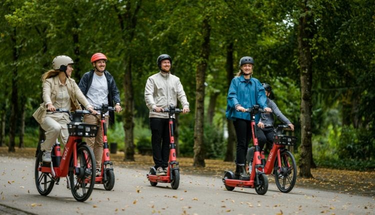 Group of people hiring electric bikes and electric scooters from Voi, getting around, Isle of Wight, bike hire, cycling