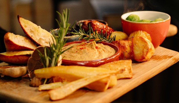 Festive tapas food on a wooden board at The Garlic Farm Restaurant, Christmas event, food and drink