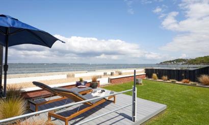 Outside loungers with umbrella facing a sea view at Sea Lights, Classic Cottages, Isle of Wight, self catering, accommodation