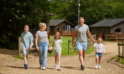Family walking around the park with the lodges in the background at Landguard Holiday Park, caravans, lodges, Shanklin, Isle of Wight