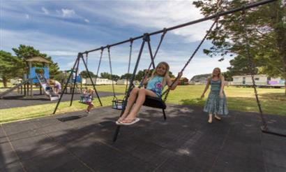 Child on the swing at the playground at Sandhills Holiday Park, Bembridge, Isle of Wight