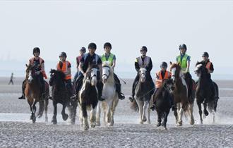 Group of people riding horses on the beach, Fairfields Farm Riding School, Ryde, Isle of Wight, children's activities, family fun, adventure rides