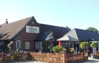Outside view of The Fighting Cocks with outside seating area, Arreton, pub