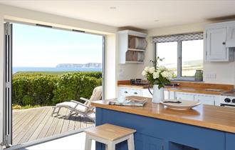 Kitchen area with folding doors onto patio at Flackstead, Isle of Wight, Self Catering