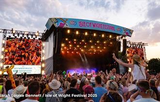 Crowds watching a band on the main stage at the Isle of Wight Festival, music event, what's on