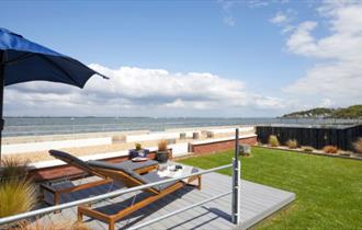 Outside loungers with umbrella facing a sea view at Sea Lights, Classic Cottages, Isle of Wight, self catering, accommodation