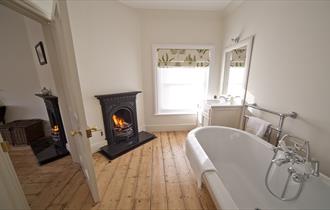 Roll-top bath with open fire at Signal Point, Ventnor Botanic Garden, Self Catering, Isle of Wight